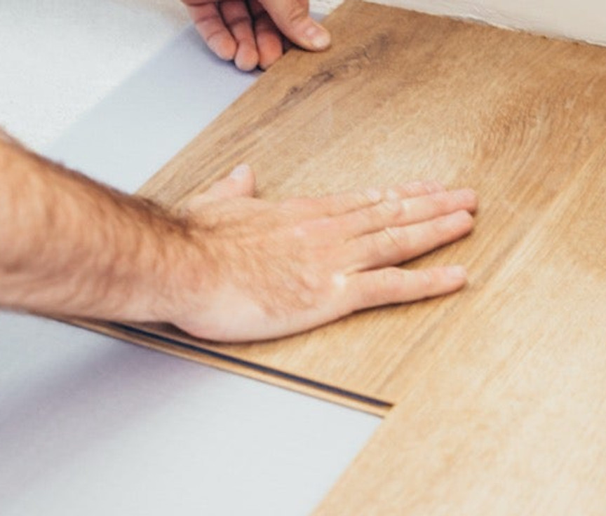 Laminate flooring being installed showing natural wood appearance